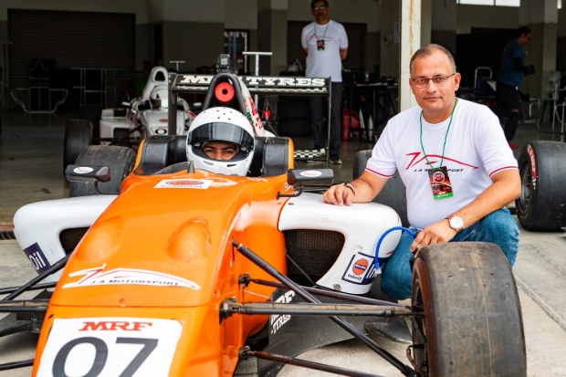 Shriya seated on the racing car along with her dad on the side.