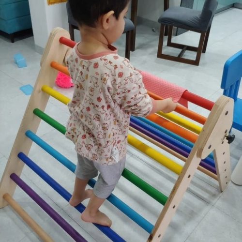  a kid playing with a wooden toy