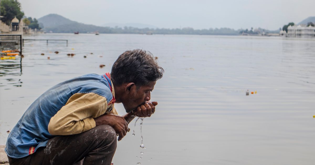 A man drinks water from the lake, reflecting its historical reverence and vital role in the community.
