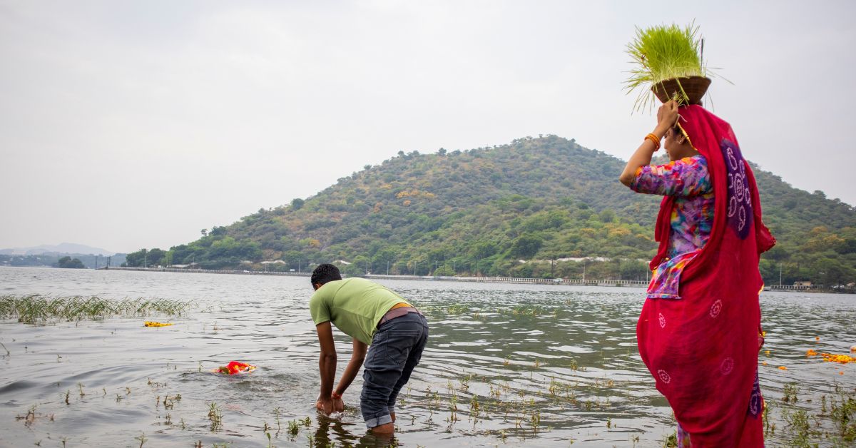 A couple immerses a Durga idol in Fateh Sagar Lake — a Navratri ritual that reflects both faith and ecological challenge.
