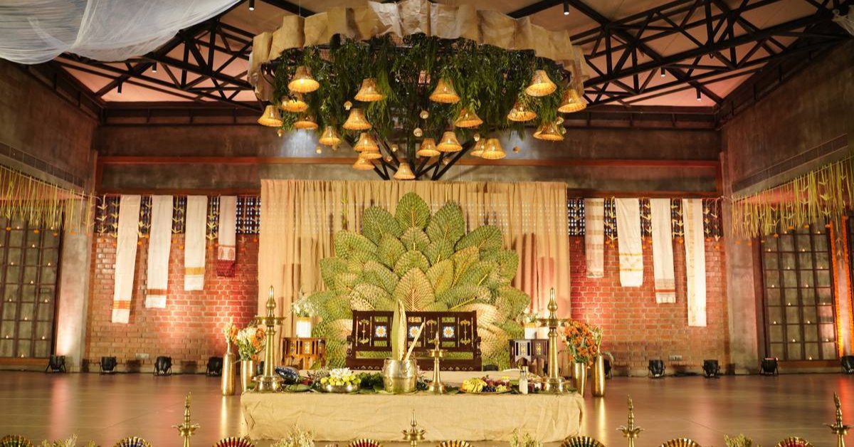 Giant palm leaves were used to create a flower-shaped art in the background of the wedding stage