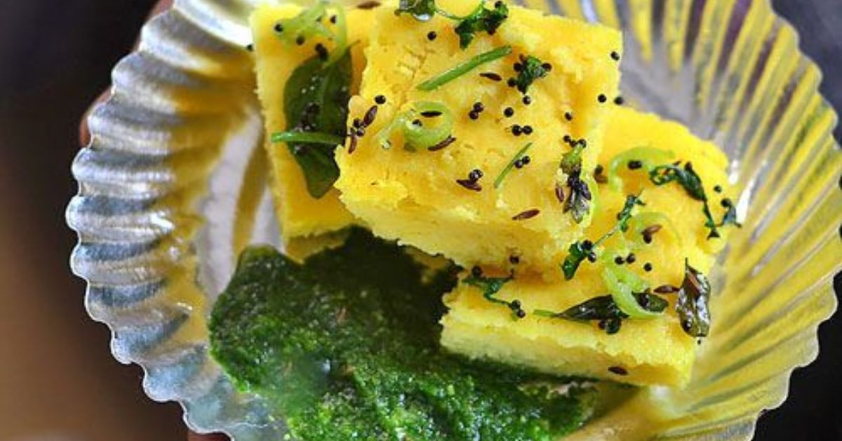 The brilliance of Dhokla (steamed savoury gram flour cake) lies in its technique: fermentation for gut health and steaming for lightness.
