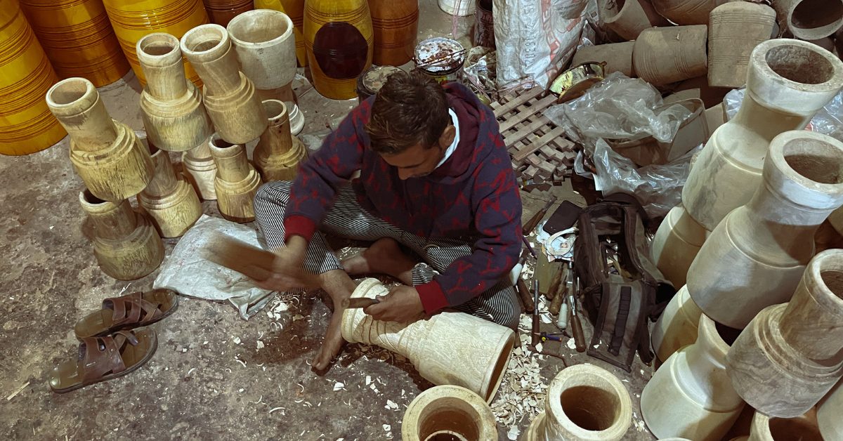 An artisan hand-carves the wooden shell, keeping alive a craft passed down through generations.