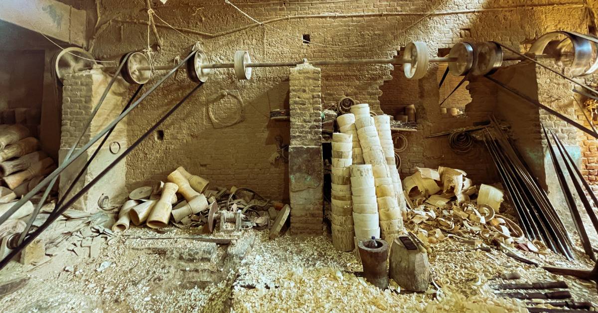 Stacks of carved wooden shells and shavings fill an Amroha workshop, where tablas take shape by hand.